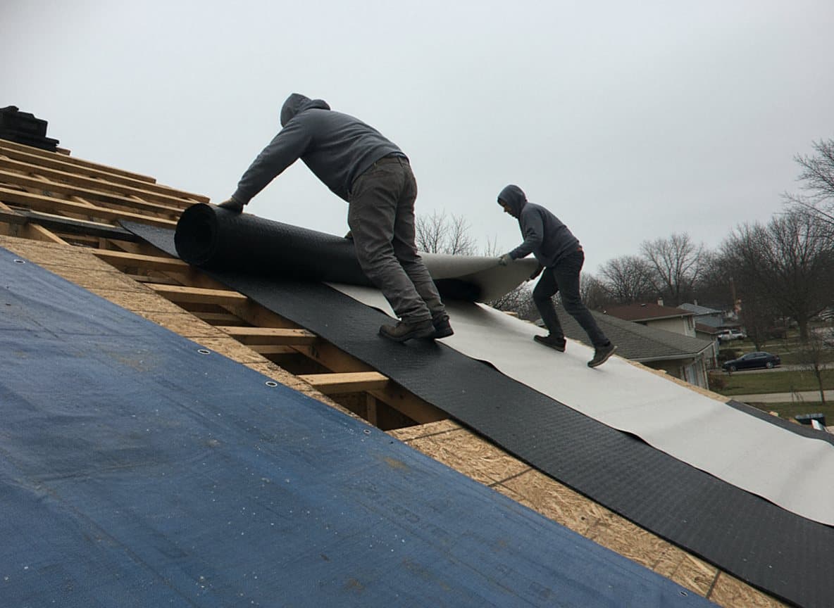 Crew laying insulation on a Dearborn commercial roof deck