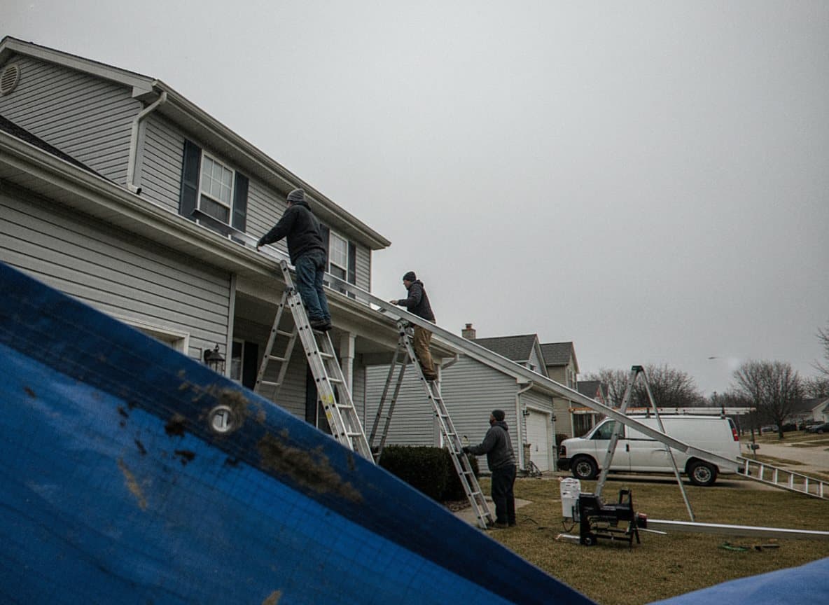 Crew hanging a seamless gutter on Dearborn fascia